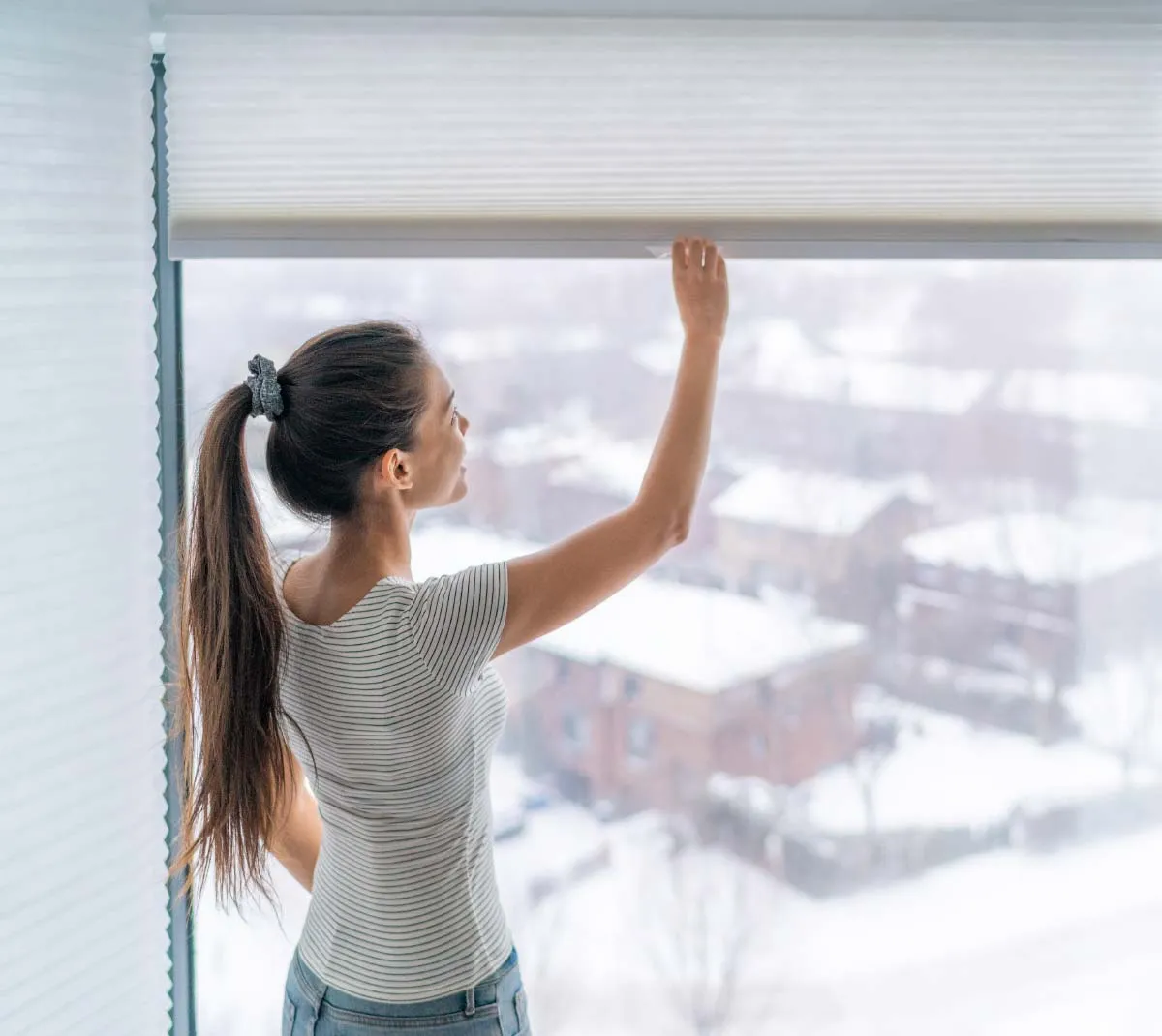 Woman opening blinds